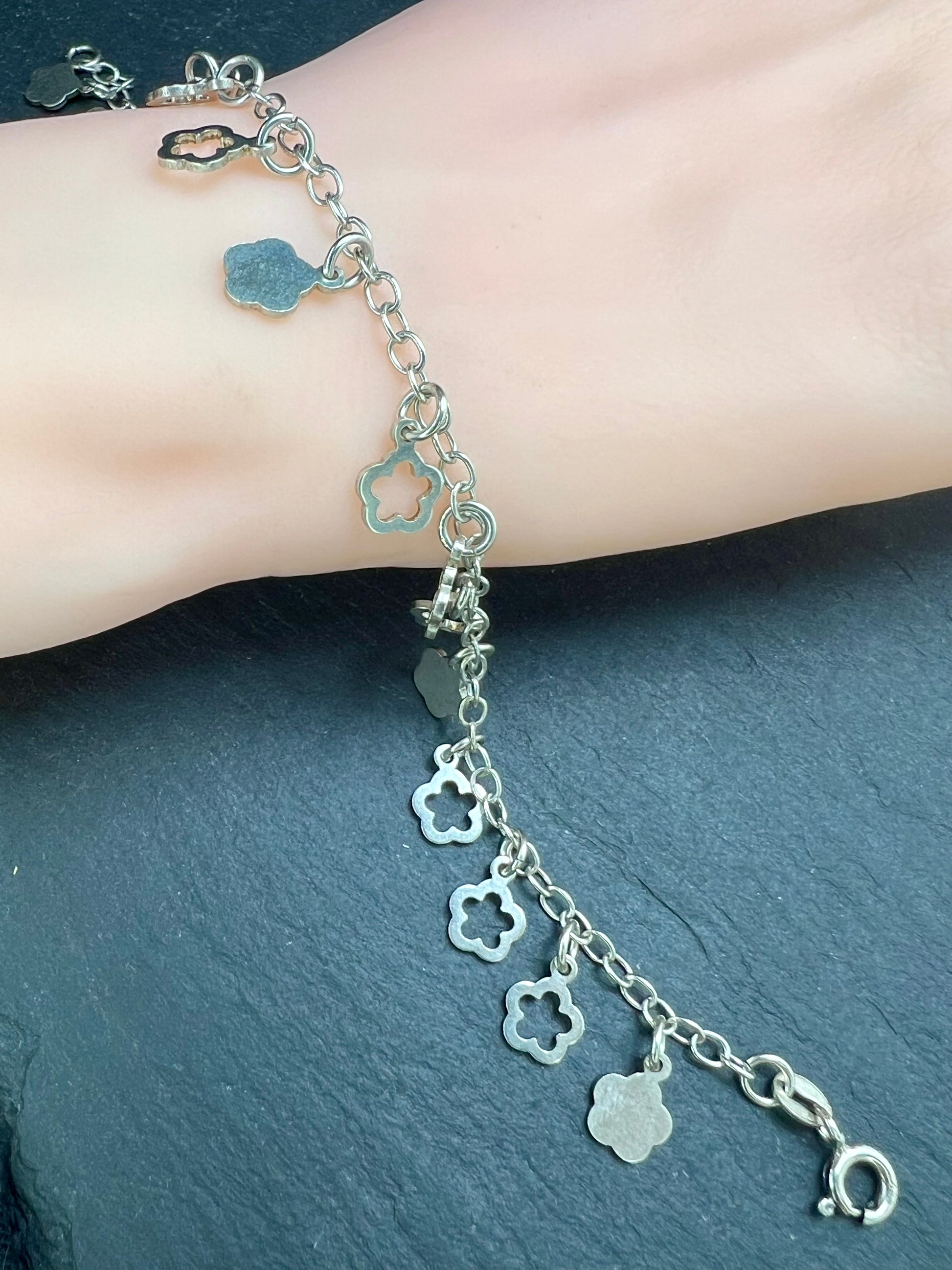 Nahaufnahme eines Vintage-Armbands aus 925 Silber mit Blümchen-Anhängern, filigraner Kette und Design aus den 1980er Jahren.