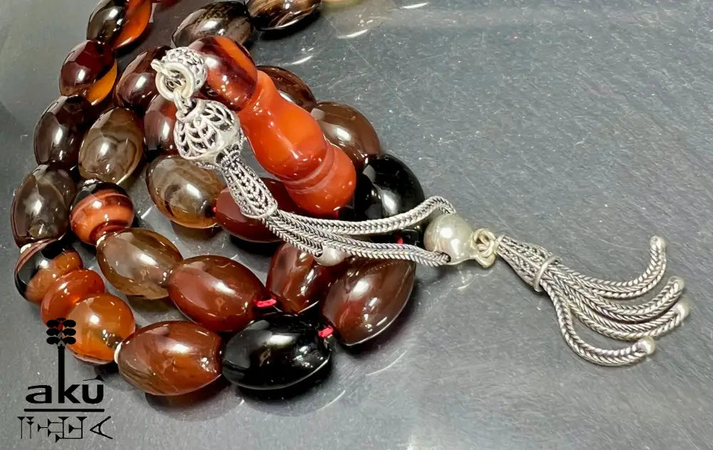 33-Perlen Tasbih aus Naturachat mit 925er Silberquaste, zeigt polierte Perlen in Brauntönen und feine Silberdetails.