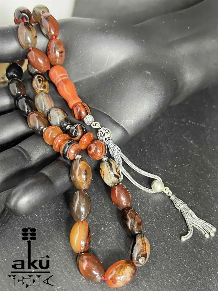 33-Perlen Tasbih aus Naturachat mit 925er Silberquaste, zeigt polierte Perlen in Brauntönen und feine Silberdetails.