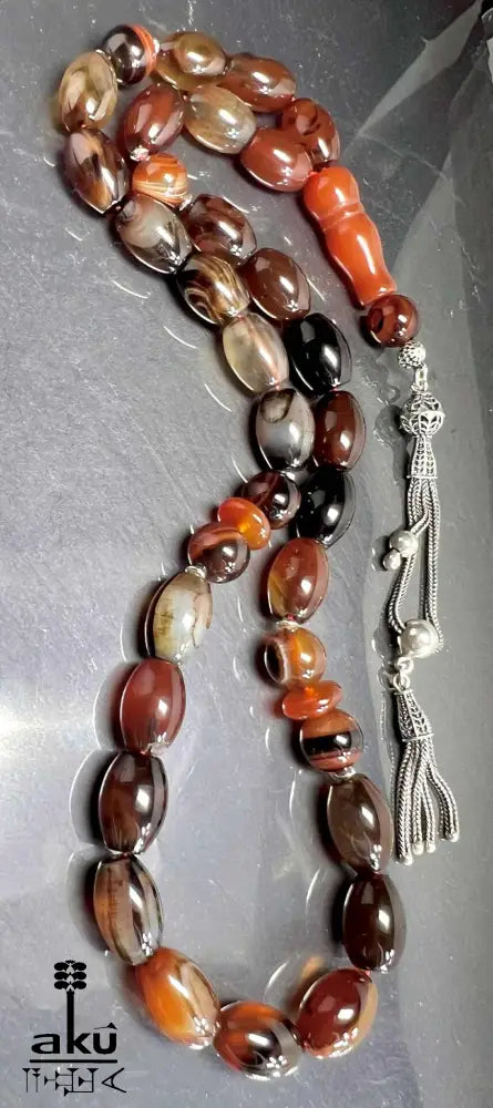 33-Perlen Tasbih aus Naturachat mit 925er Silberquaste, zeigt polierte Perlen in Brauntönen und feine Silberdetails.
