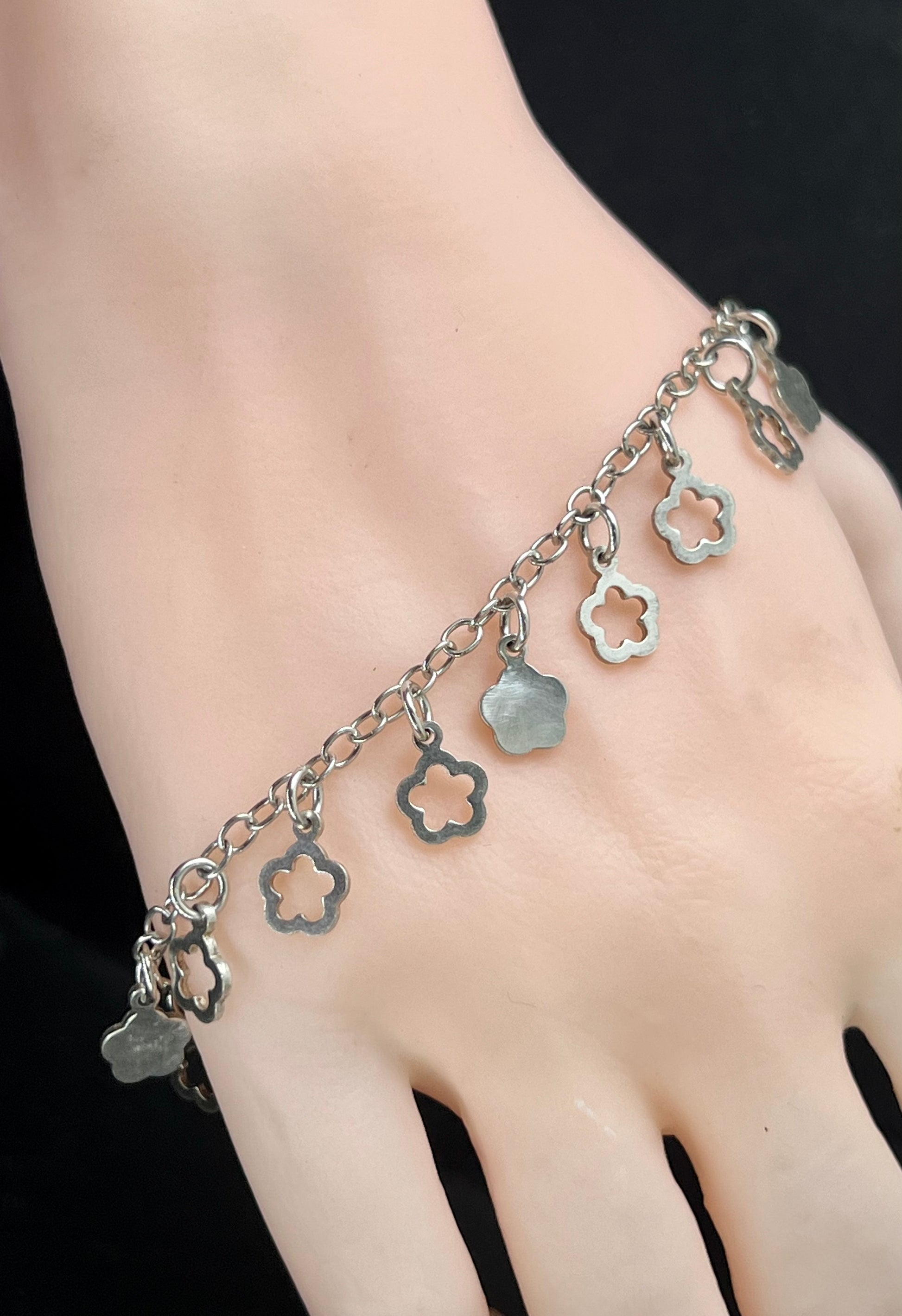 Nahaufnahme eines Vintage-Armbands aus 925 Silber mit Blümchen-Anhängern, filigraner Kette und Design aus den 1980er Jahren.