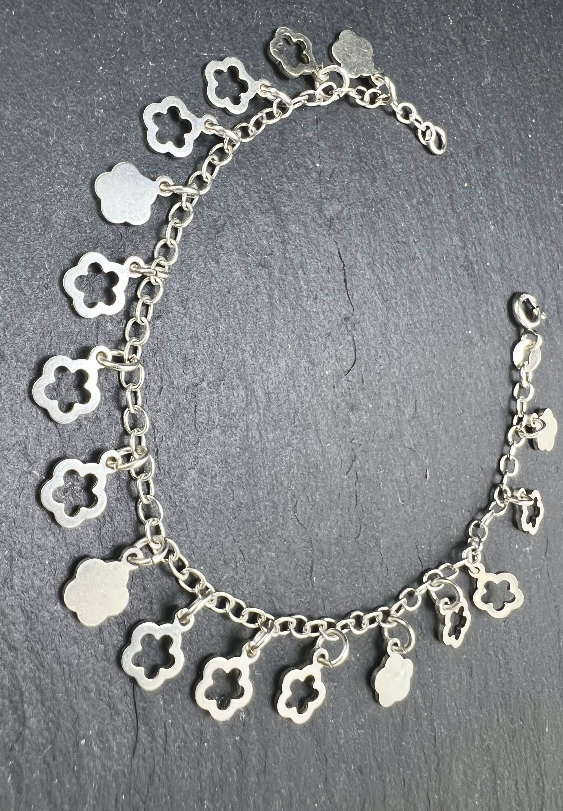 Nahaufnahme eines Vintage-Armbands aus 925 Silber mit Blümchen-Anhängern, filigraner Kette und Design aus den 1980er Jahren.