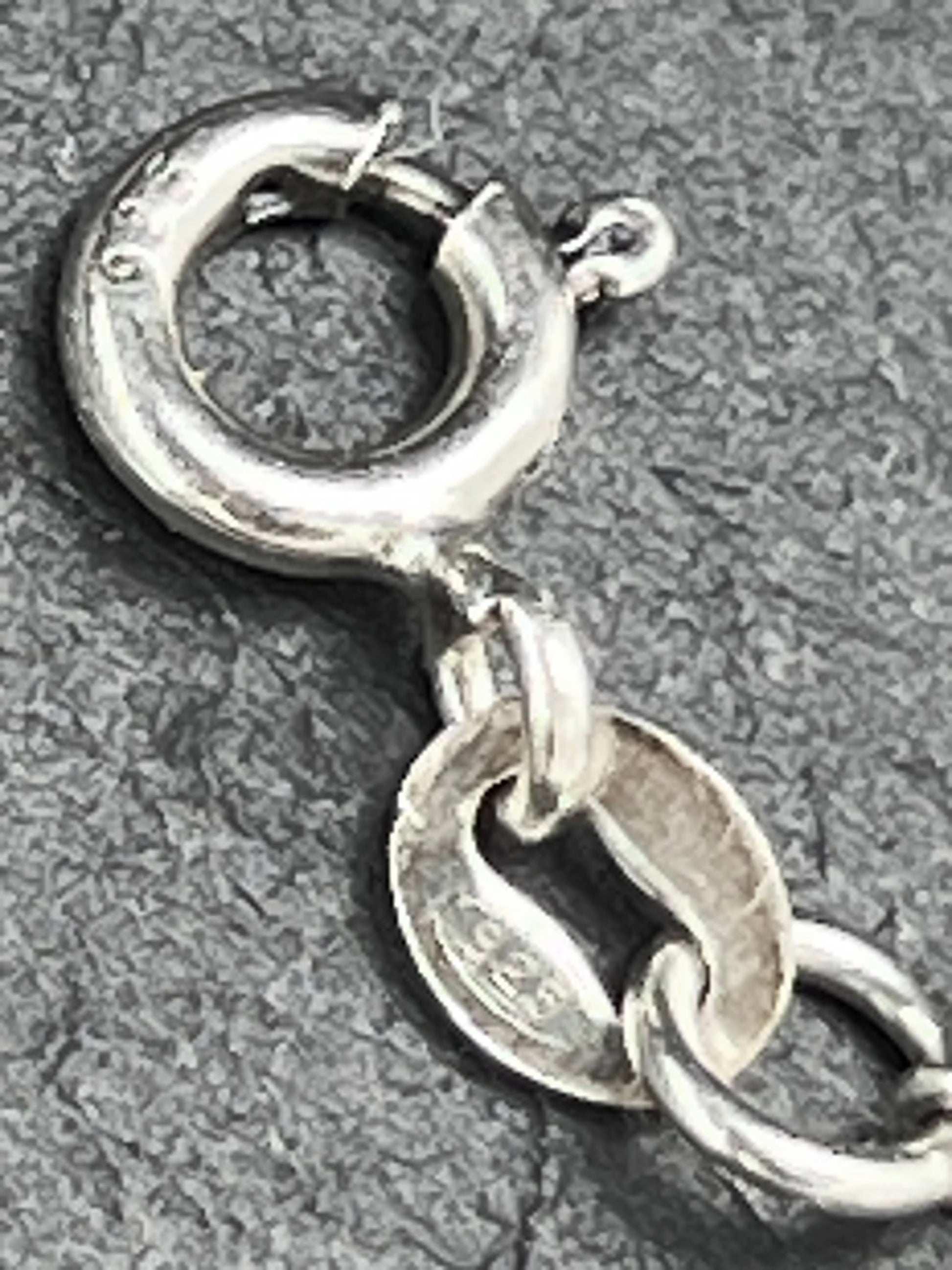 Nahaufnahme eines Vintage-Armbands aus 925 Silber mit Blümchen-Anhängern, filigraner Kette und Design aus den 1980er Jahren.