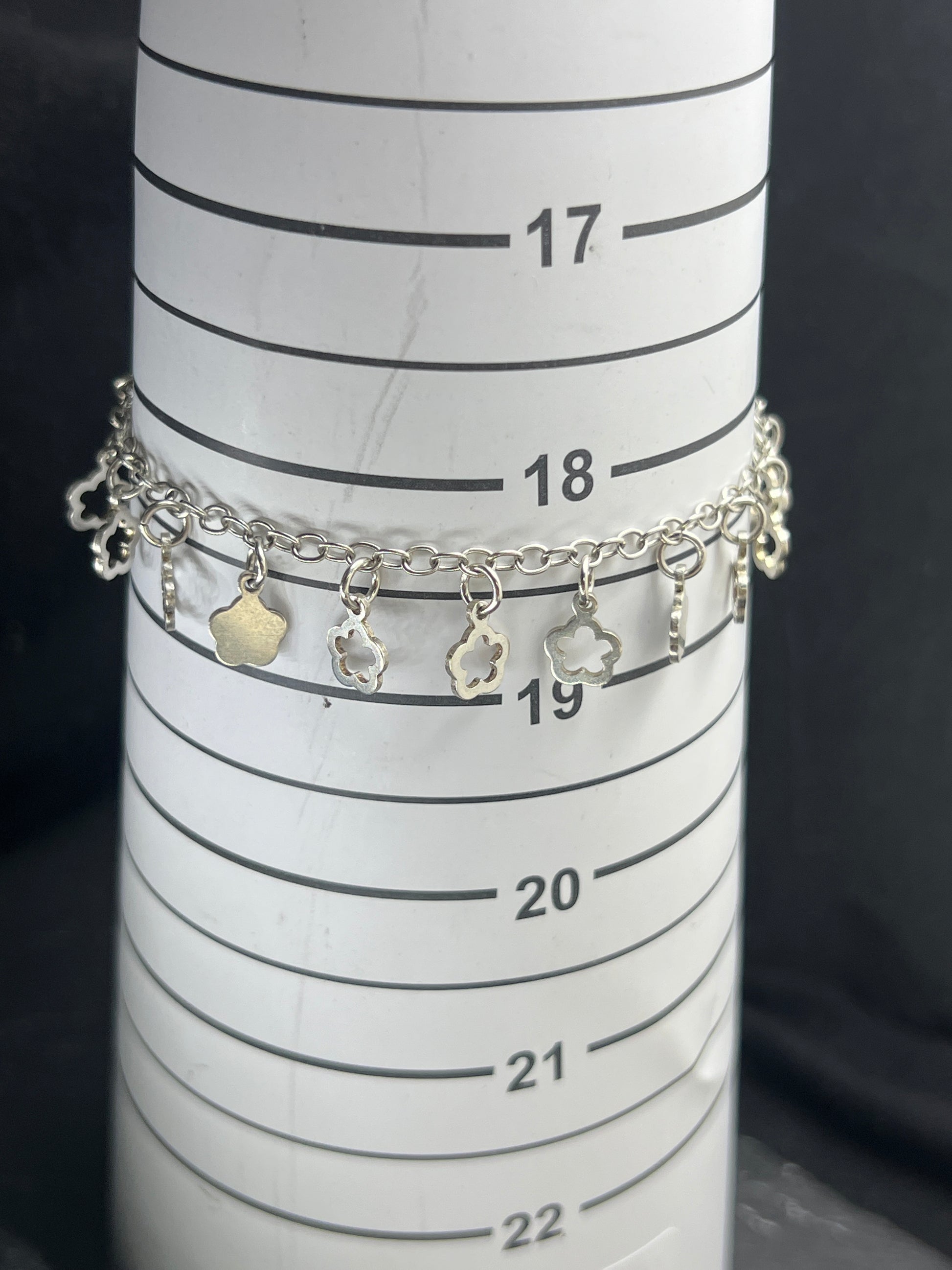 Nahaufnahme eines Vintage-Armbands aus 925 Silber mit Blümchen-Anhängern, filigraner Kette und Design aus den 1980er Jahren.