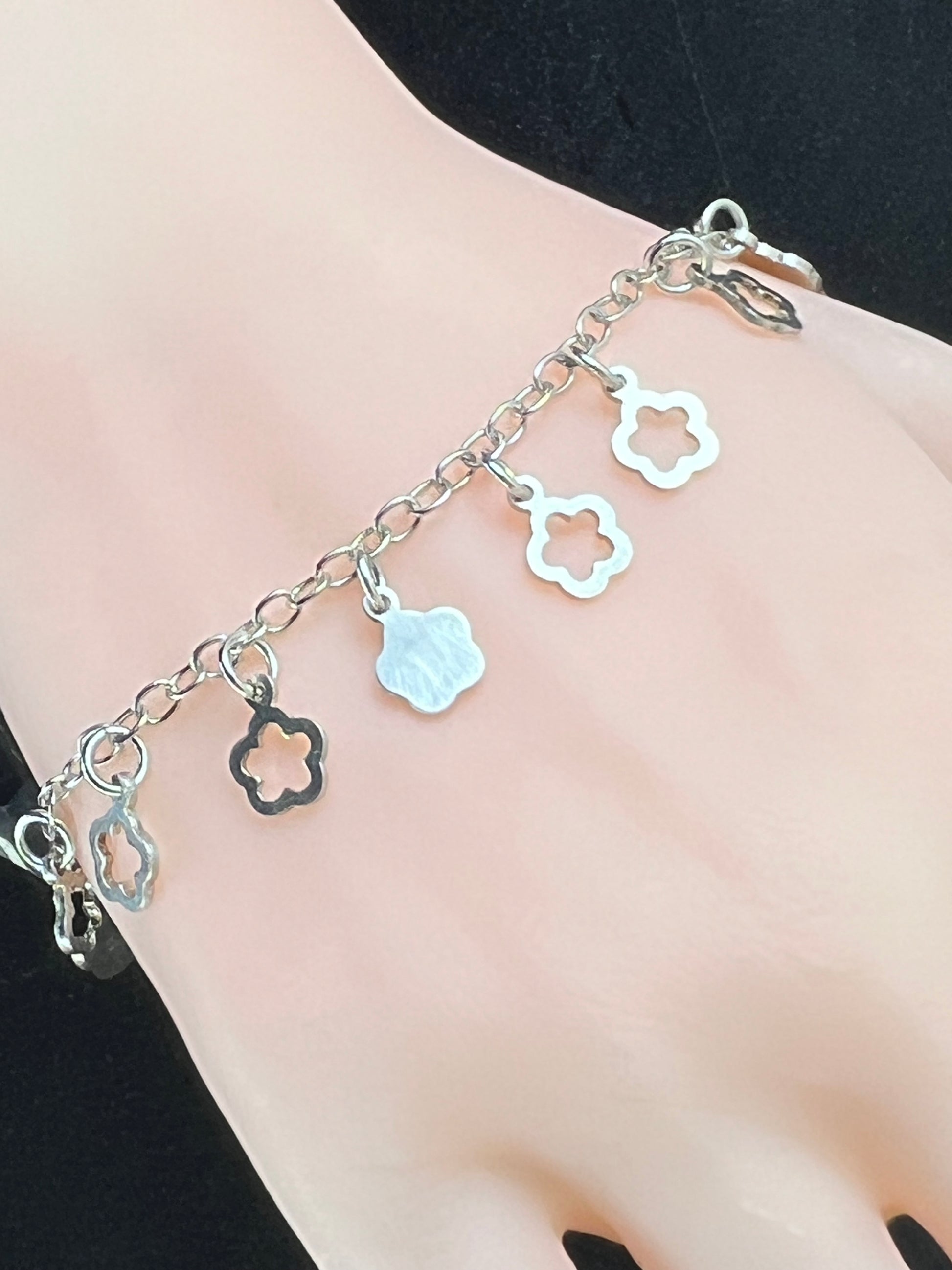 Nahaufnahme eines Vintage-Armbands aus Silber mit Blümchen-Anhängern, filigraner Kette und Design aus den 1980er Jahren.