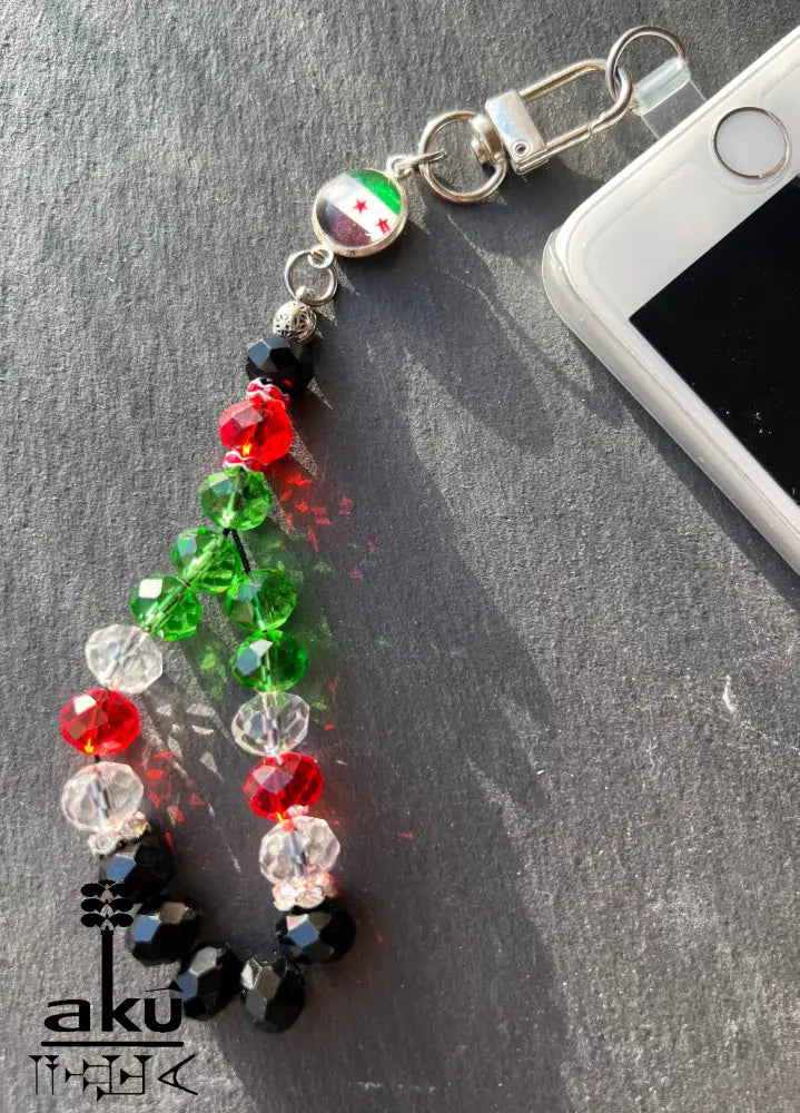 Handykette aus glänzenden Kristale Glasperlen in Form eines kleinen Gebetskranzes vereint ein verspieltes Design mit einer kleinen Flaggenmedaille.