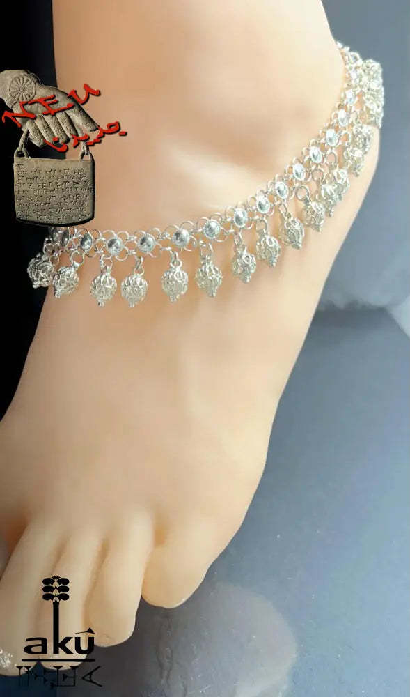 Detailaufnahme eines indischen 925er Silber-Fußkettchens mit Glöckchenanhängern am Knöchel getragen – traditioneller Schmuck mit filigraner Verarbeitung.