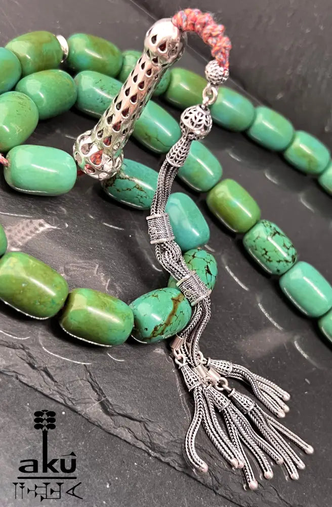 33er Tasbih aus natürlich türkisem Chrysokoll, 18×13 mm zylinderförmige Perlen, 5 cm Minarett aus 925er Sterlingsilber, 40+13 cm Länge, 186 g Gewicht, mit goldfarbener Seidenquaste.