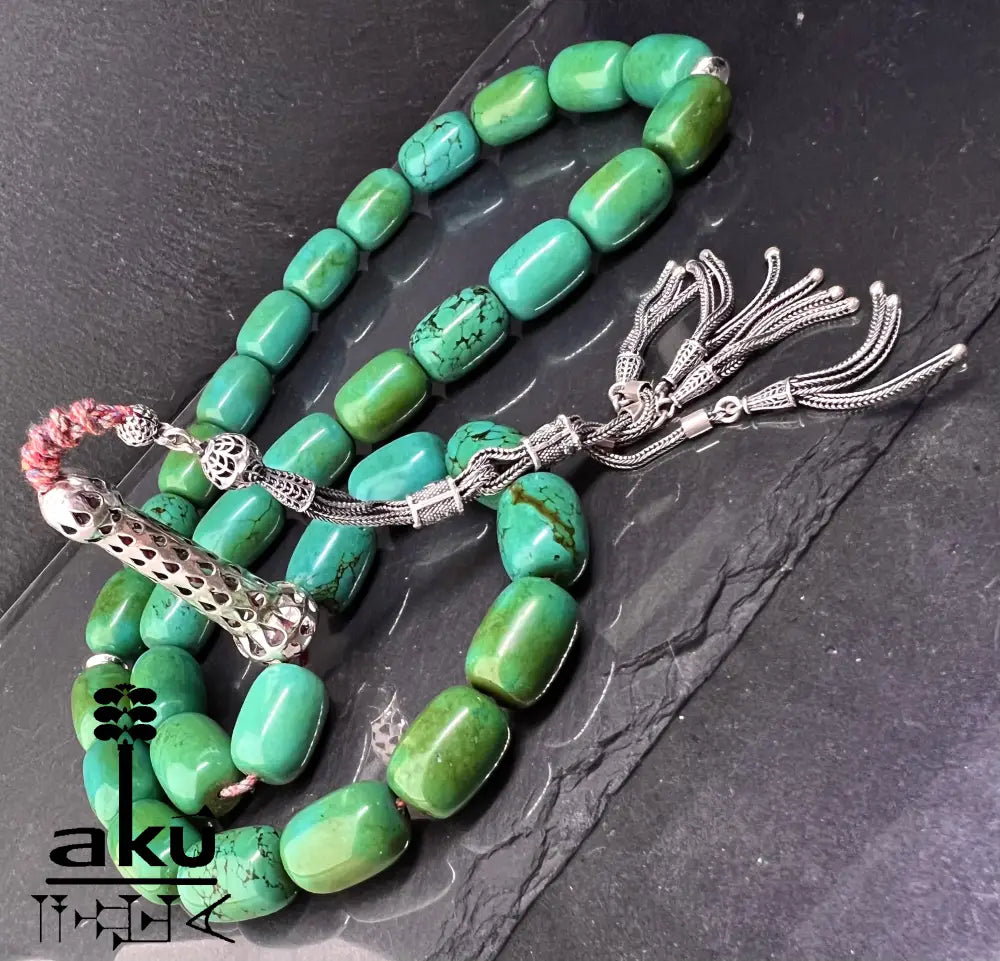 33er Tasbih aus natürlich türkisem Chrysokoll, 18×13 mm zylinderförmige Perlen, 5 cm Minarett aus 925er Sterlingsilber, 40+13 cm Länge, 186 g Gewicht, mit goldfarbener Seidenquaste.