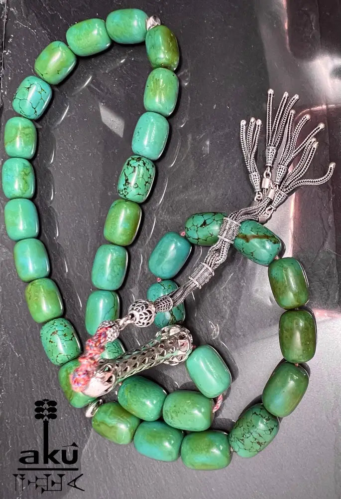 33er Tasbih aus natürlich türkisem Chrysokoll, 18×13 mm zylinderförmige Perlen, 5 cm Minarett aus 925er Sterlingsilber, 40+13 cm Länge, 186 g Gewicht, mit goldfarbener Seidenquaste.