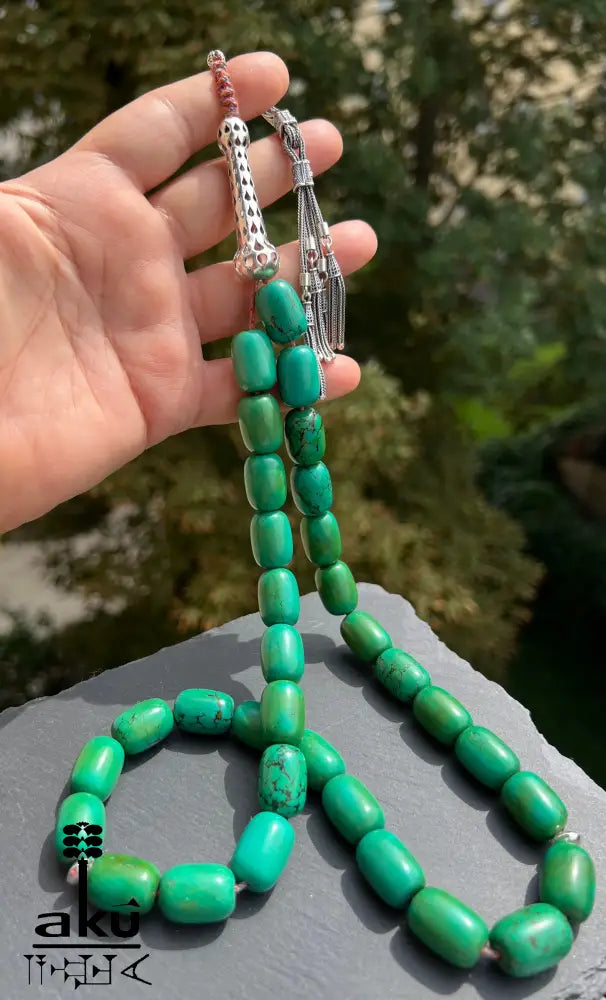 33er Tasbih aus natürlich türkisem Chrysokoll, 18×13 mm zylinderförmige Perlen, 5 cm Minarett aus 925er Sterlingsilber, 40+13 cm Länge, 186 g Gewicht, mit goldfarbener Seidenquaste.