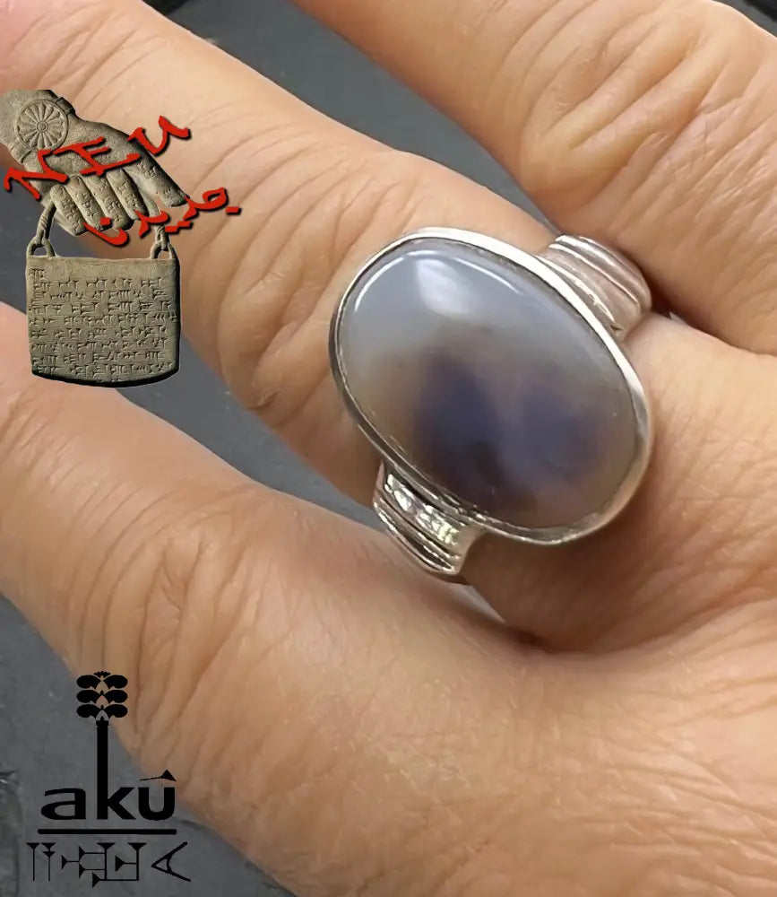 Hand mit Silberring, Stein zeigt dunkle Silhouetten