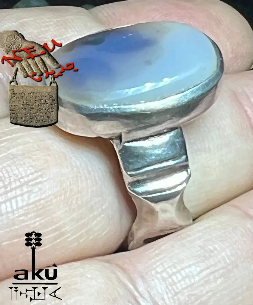 Hand mit Silberring, Stein zeigt dunkle Silhouetten