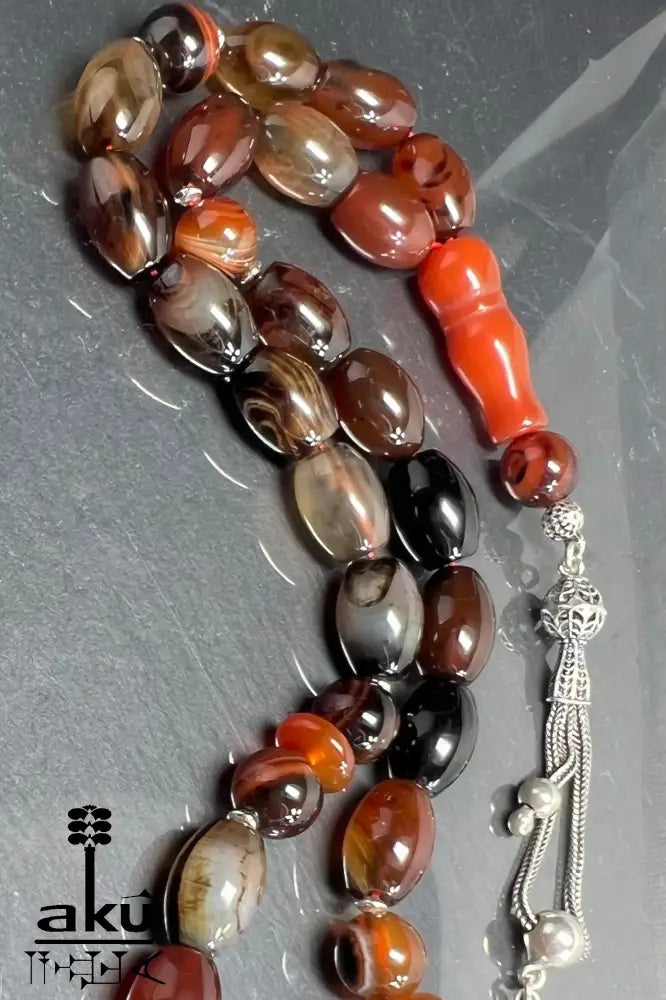 33-Perlen Tasbih aus Naturachat mit 925er Silberquaste, zeigt polierte Perlen in Brauntönen und feine Silberdetails.