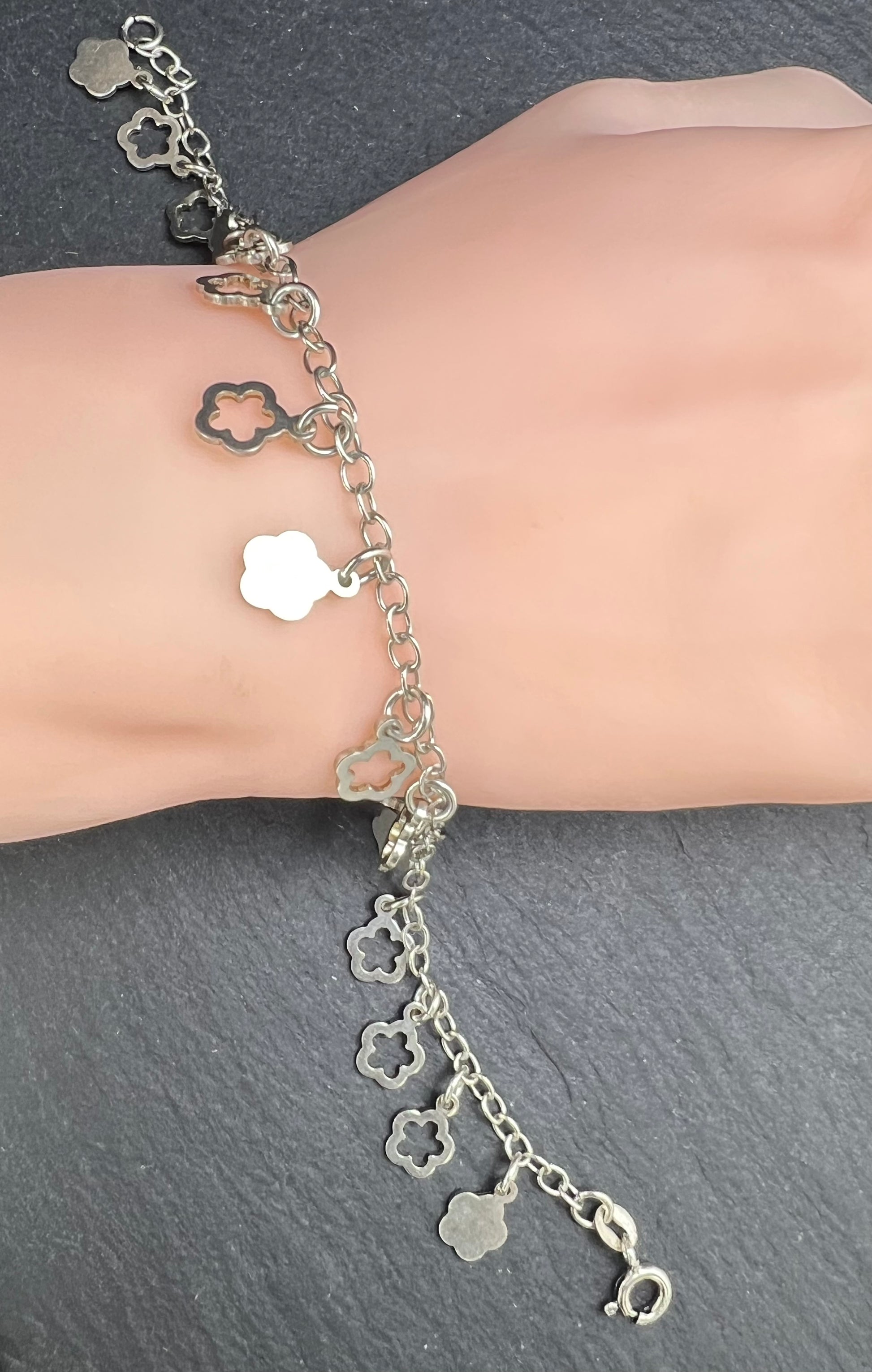 Nahaufnahme eines Vintage-Armbands aus 925 Silber mit Blümchen-Anhängern, filigraner Kette und Design aus den 1980er Jahren.