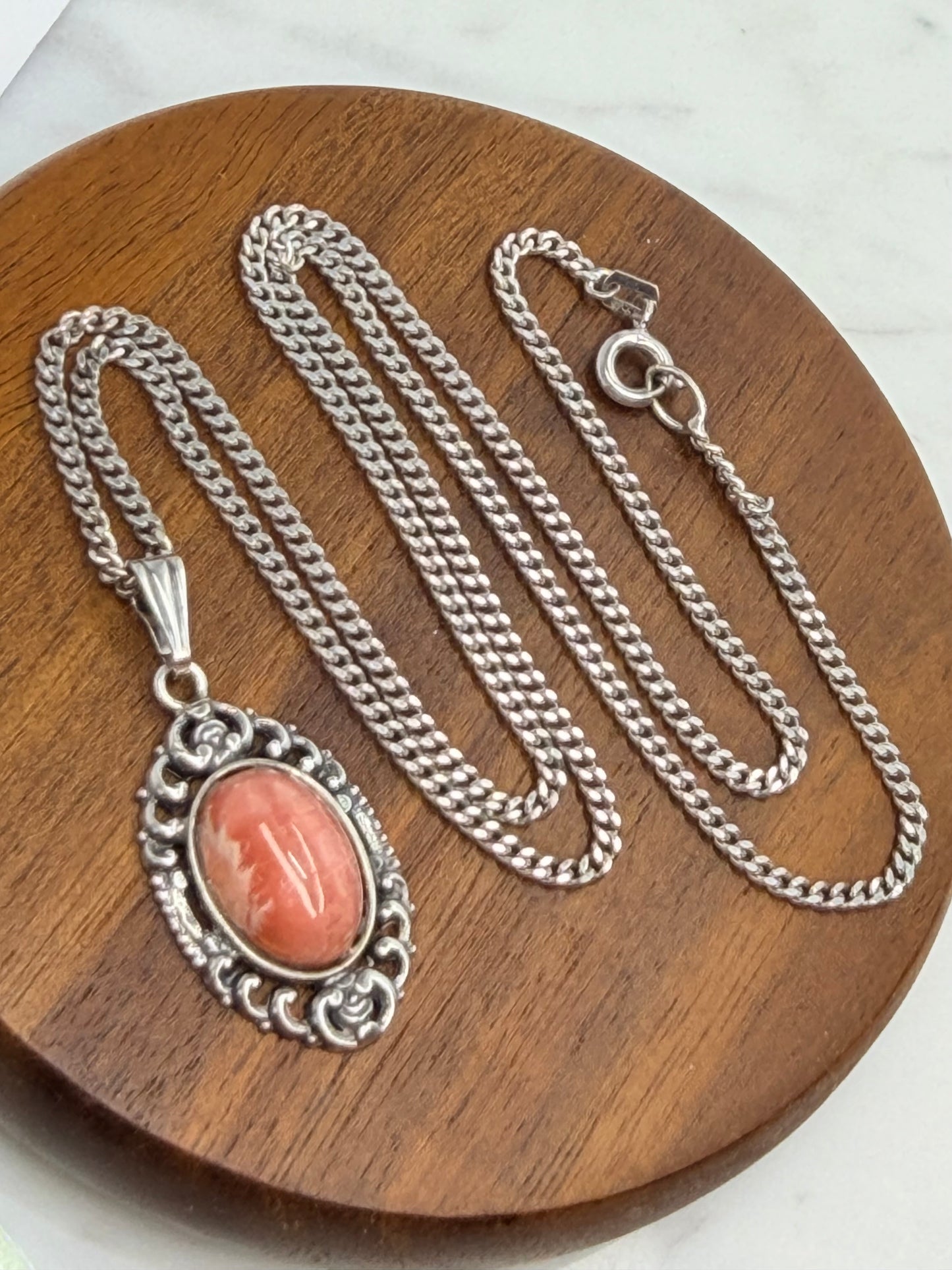 Vintage Rhodochrosit Anhänger Kette – Elegantes, verziertes Silber, Klassische Eleganz. Auf Holz