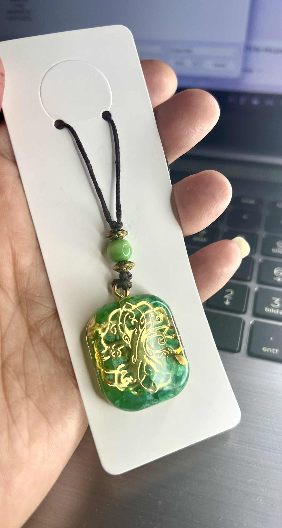 Anhänger Halskette aus grünem Kunstharz mit goldfarbenen Einlagen und einem filigranen Lebensbaum-Motiv. Der Baum des Lebens