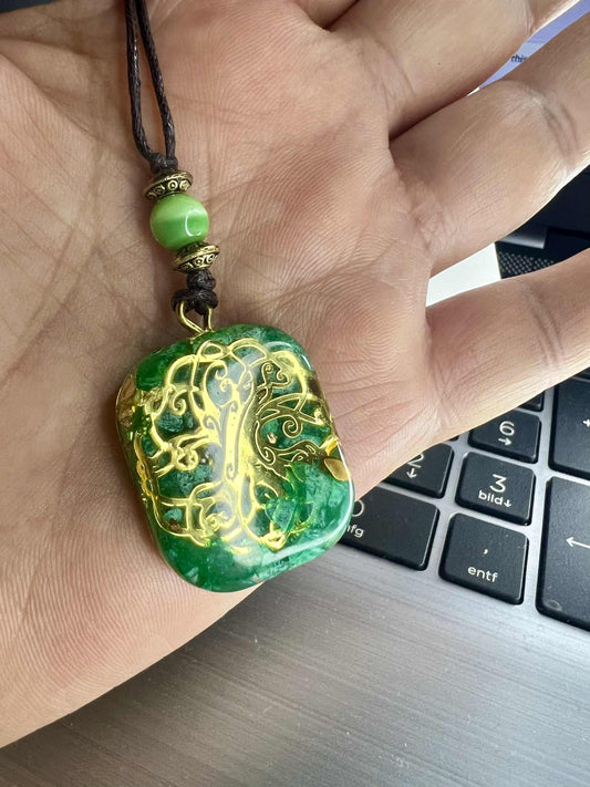 Anhänger Halskette aus grünem Kunstharz mit goldfarbenen Einlagen und einem filigranen Lebensbaum-Motiv. Der Baum des Lebens