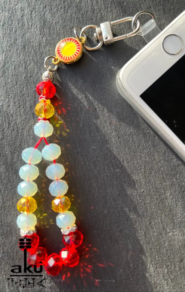 Handykette aus glänzenden Kristale Glasperlen&nbsp;in Form eines kleinen Gebetskranzes vereint ein verspieltes Design mit einer kleinen Flaggenmedaille.