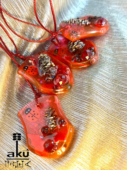 Handgefertigte Weihnachtsanhänger aus rotem Glitzerharz mit natürlichen Einschlüssen