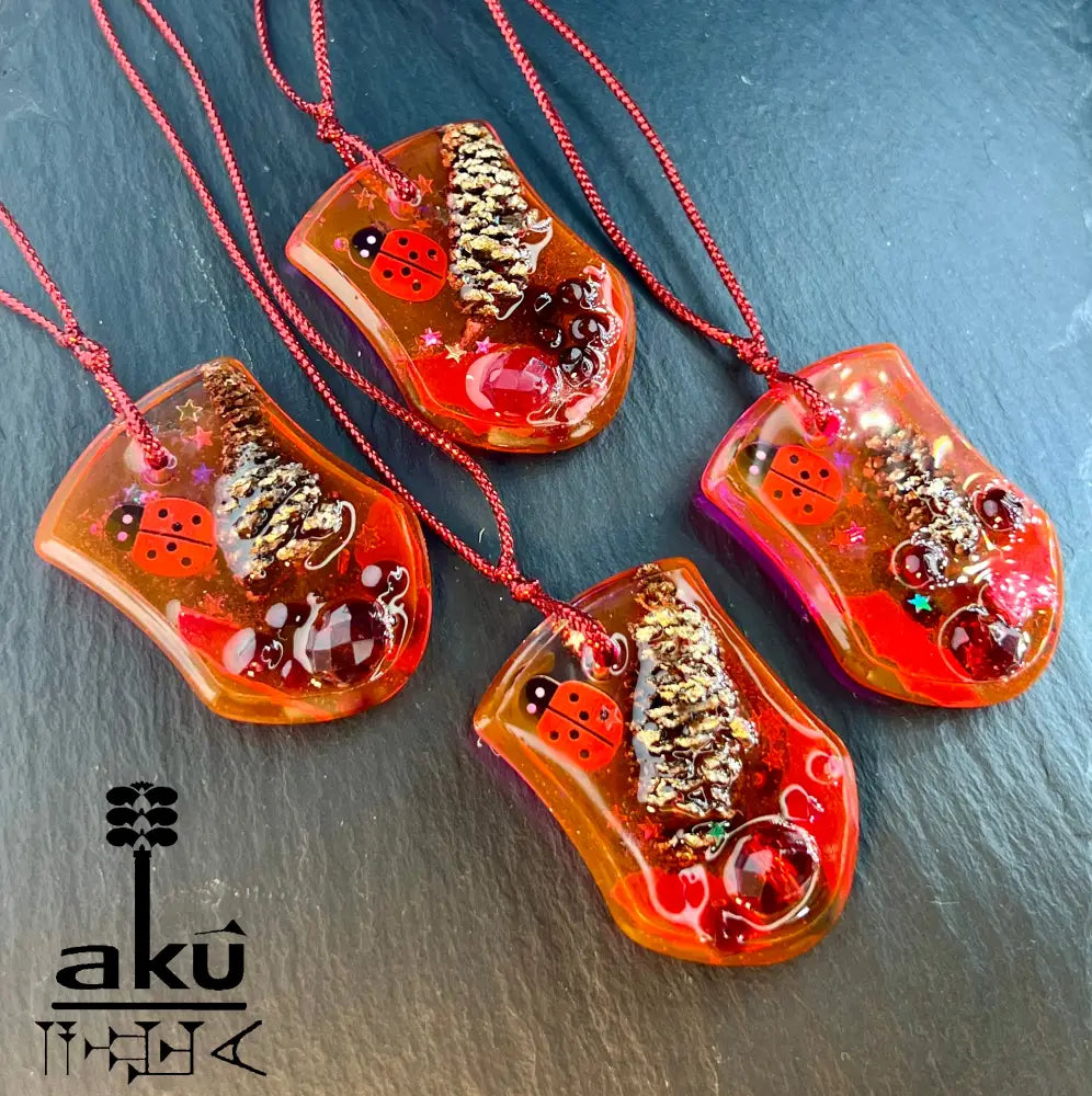 Handgefertigte Weihnachtsanhänger aus rotem Glitzerharz mit natürlichen Einschlüssen