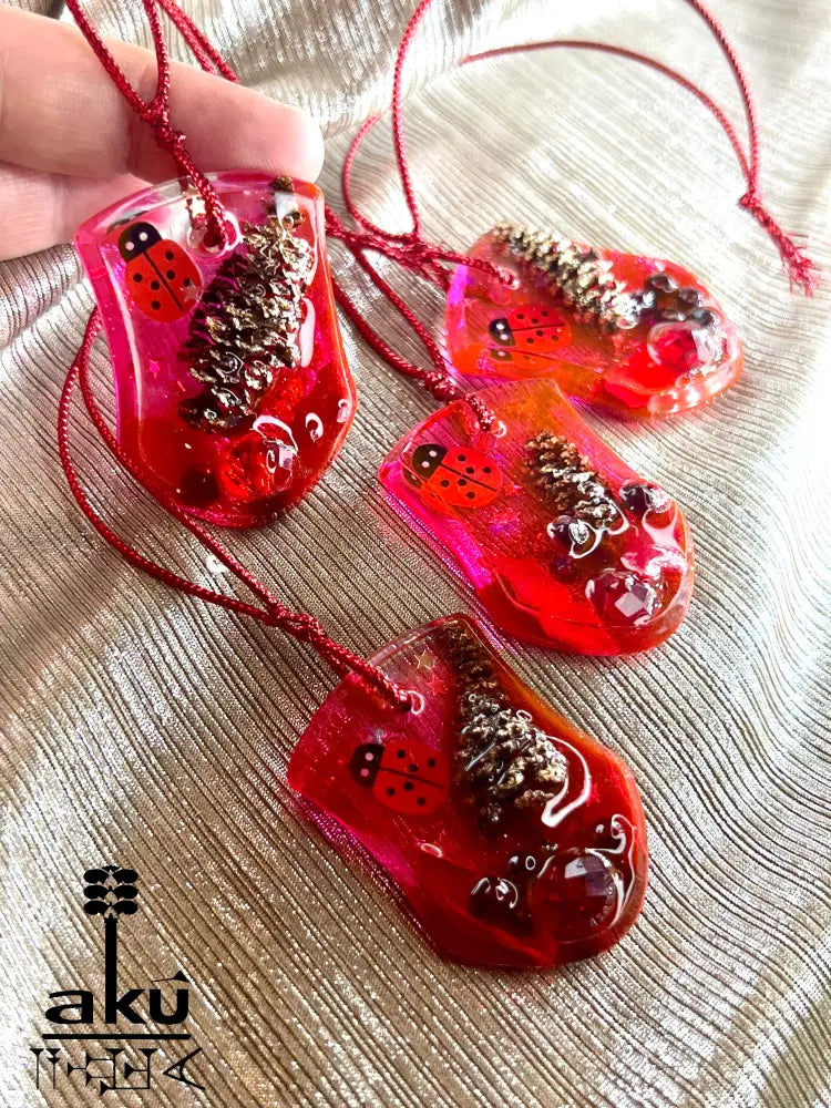 Handgefertigte Weihnachtsanhänger aus rotem Glitzerharz mit natürlichen Einschlüssen