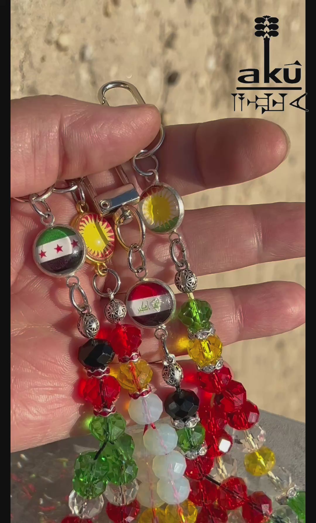 Handykette aus glänzenden Kristale Glasperlen&nbsp;in Form eines kleinen Gebetskranzes vereint ein verspieltes Design mit einer kleinen Flaggenmedaille.