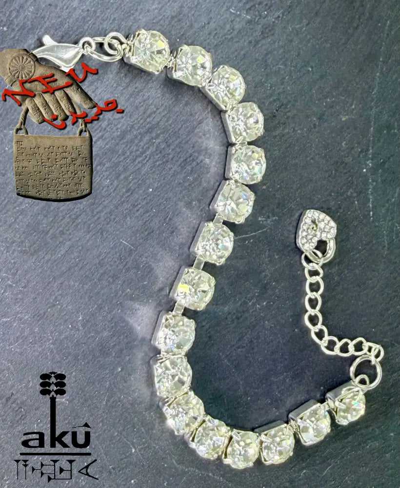 Strasssteinen einreihiges Armband, auf dunklem Hintergrund. Nahaufnahme der Herz-Charms und Karabinerverschlüsse