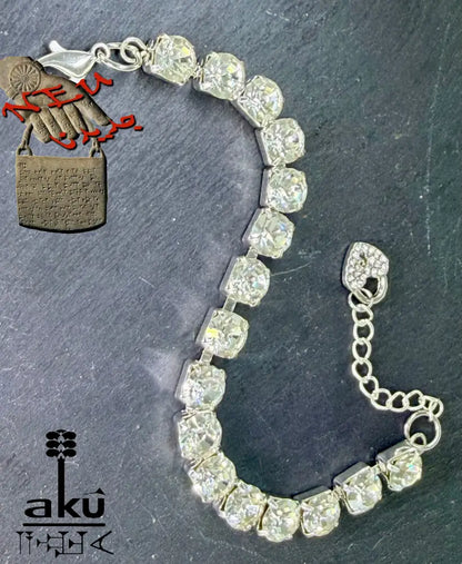 Strasssteinen einreihiges Armband, auf dunklem Hintergrund. Nahaufnahme der Herz-Charms und Karabinerverschlüsse