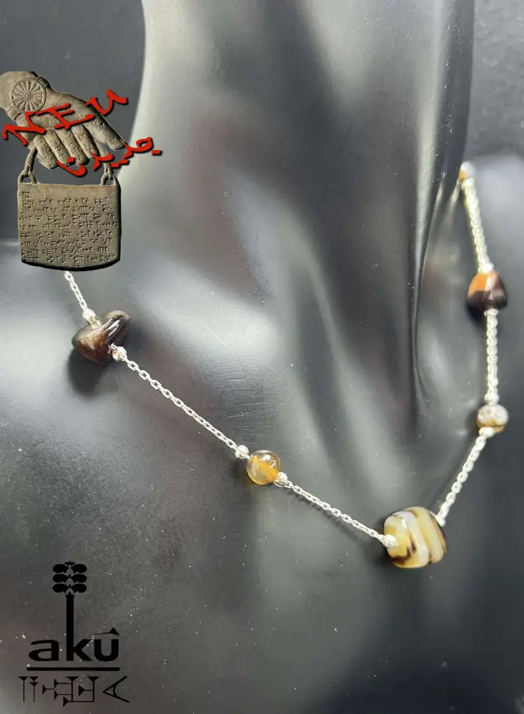 Detailaufnahme einer 925er Sterling Silberkette mit natürlichen Achat-Nugget-Perlen in Braun-, achat Halskette auf schwarzem Display.