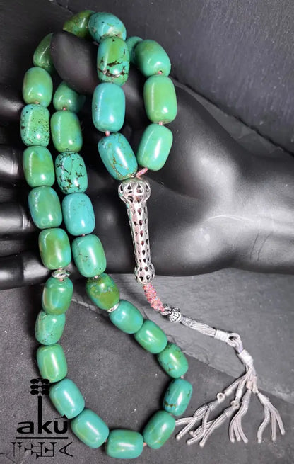 33er Tasbih aus natürlich türkisem Chrysokoll, 18×13 mm zylinderförmige Perlen, 5 cm Minarett aus 925er Sterlingsilber, 40+13 cm Länge, 186 g Gewicht, mit goldfarbener Seidenquaste.