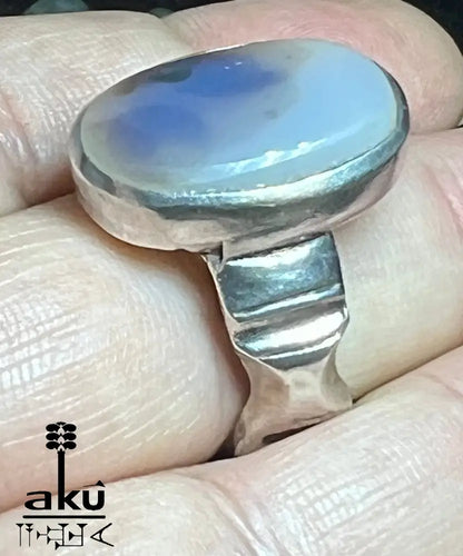 Hand mit Silberring, Stein zeigt dunkle Silhouetten